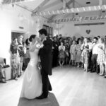 Black and white image of bridge and groom enjoying their first dance at East Dean Village Hall